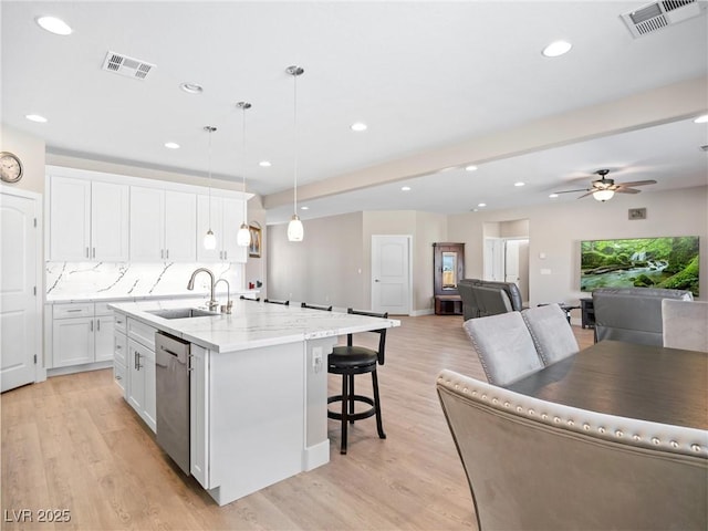 1500 E Laguna St, Pahrump, NV 89048 - kitchen featuring dishwasher, a sink, a kitchen island with sink, open floor plan, and a breakfast bar