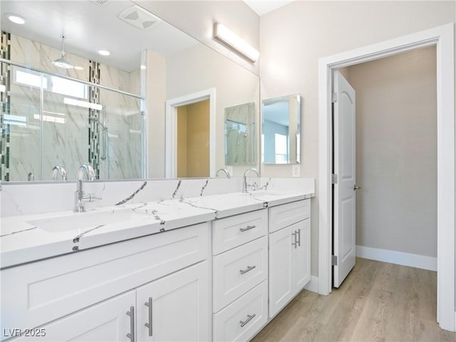 1500 E Laguna St, Pahrump, NV 89048 - full bathroom featuring a marble finish shower, double vanity, wood finished floors, and baseboards