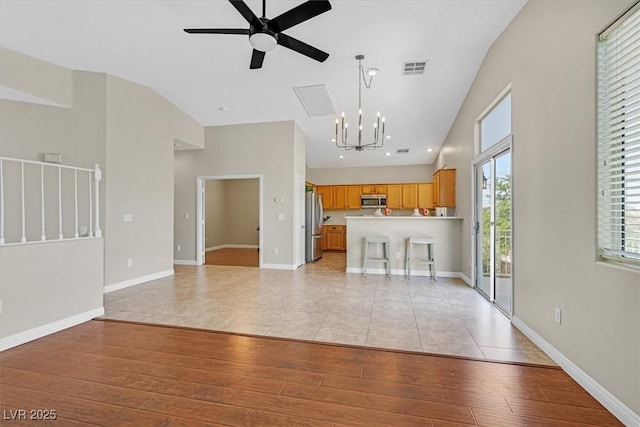 11022 Saint Rafael St, Las Vegas, NV 89141 - unfurnished living room featuring a chandelier, a ceiling fan, light wood-style floors, and baseboards
