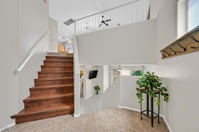 11022 Saint Rafael St, Las Vegas, NV 89141 - staircase with tile patterned flooring, a towering ceiling, and baseboards