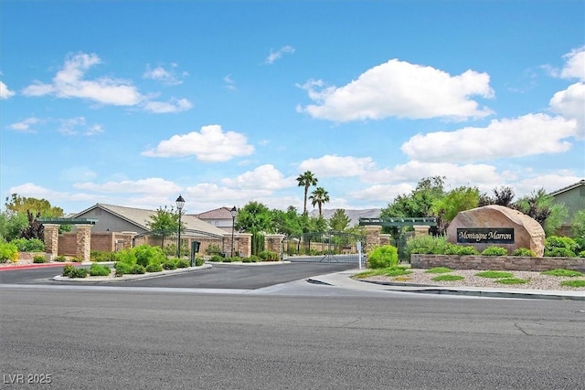 11022 Saint Rafael St, Las Vegas, NV 89141 - view of asphalt road with curbs, street lights, a gated entry, a gate, and sidewalks