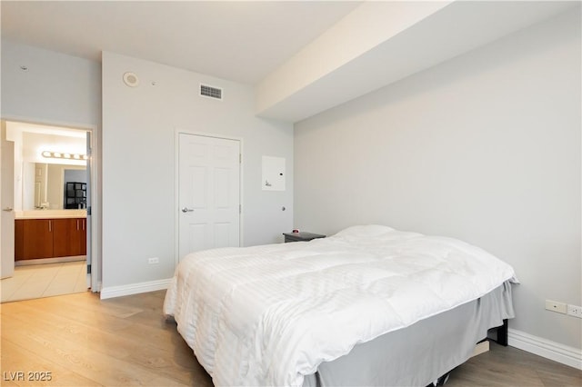 200 W Sahara Ave Unit 910, Las Vegas, NV 89102 - bedroom with light wood-style flooring, baseboards, and ensuite bathroom