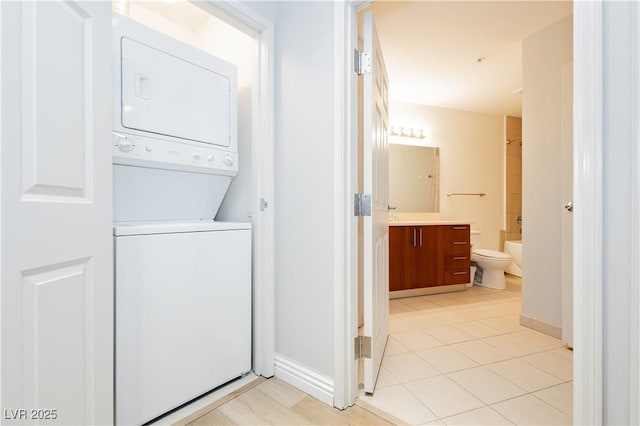 200 W Sahara Ave Unit 910, Las Vegas, NV 89102 - laundry room with stacked washing machine and dryer, light tile patterned floors, and baseboards