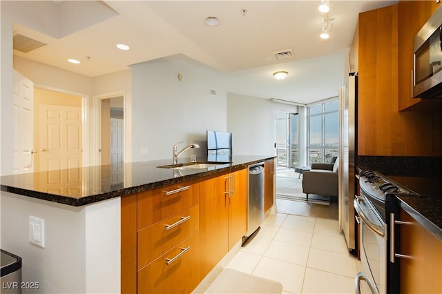200 W Sahara Ave Unit 910, Las Vegas, NV 89102 - kitchen featuring stainless steel appliances, brown cabinetry, a sink, modern cabinets, and floor to ceiling windows