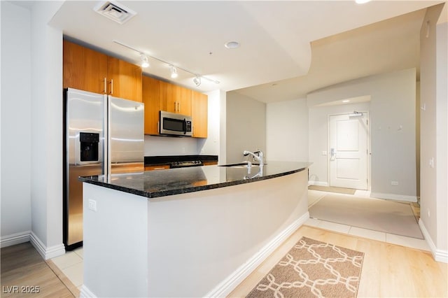 200 W Sahara Ave Unit 910, Las Vegas, NV 89102 - kitchen with stainless steel appliances, rail lighting, a sink, and light wood-style flooring