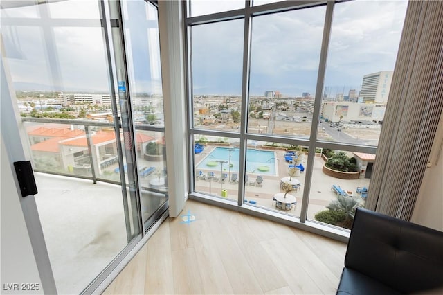 200 W Sahara Ave Unit 910, Las Vegas, NV 89102 - doorway to outside with a view of city, wood finished floors, and a wall of windows