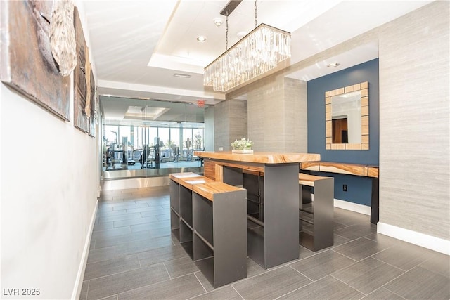 200 W Sahara Ave Unit 910, Las Vegas, NV 89102 - bar with baseboards, a chandelier, recessed lighting, a tray ceiling, and decorative light fixtures
