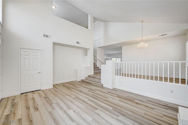 301 Lakewood Garden Dr, Las Vegas, NV 89148 - unfurnished room featuring high vaulted ceiling, wood finished floors, a chandelier, baseboards, and stairway