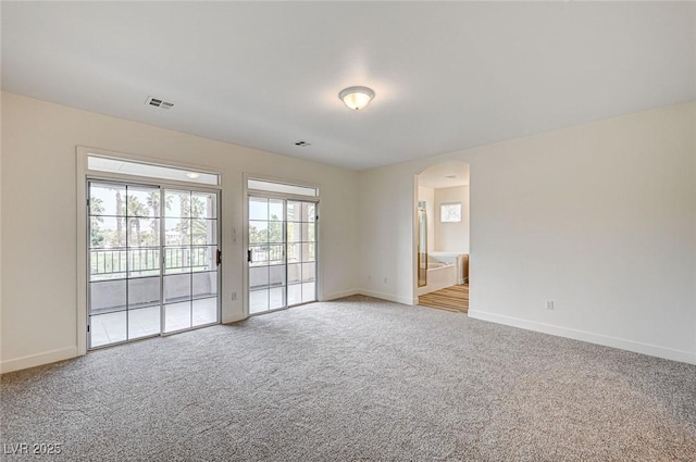 301 Lakewood Garden Dr, Las Vegas, NV 89148 - spare room featuring arched walkways, baseboards, and light colored carpet