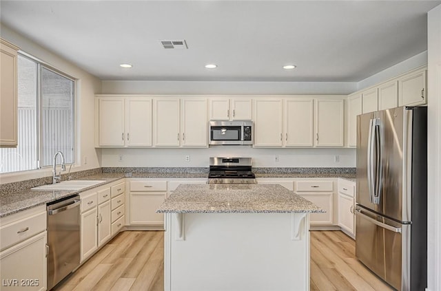 301 Lakewood Garden Dr, Las Vegas, NV 89148 - kitchen with stainless steel appliances, light wood-style flooring, a sink, a center island, and recessed lighting