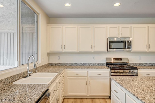 301 Lakewood Garden Dr, Las Vegas, NV 89148 - kitchen with appliances with stainless steel finishes, a sink, white cabinetry, recessed lighting, and light wood-type flooring
