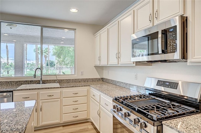 301 Lakewood Garden Dr, Las Vegas, NV 89148 - kitchen featuring appliances with stainless steel finishes, a sink, light stone counters, white cabinets, and recessed lighting