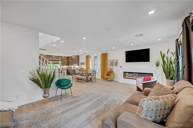 7756 Seville Estates Ct, Las Vegas, NV 89113 - living area with stairs, light wood-type flooring, a glass covered fireplace, recessed lighting, and baseboards