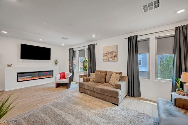 7756 Seville Estates Ct, Las Vegas, NV 89113 - living room featuring a glass covered fireplace, baseboards, wood finished floors, and recessed lighting