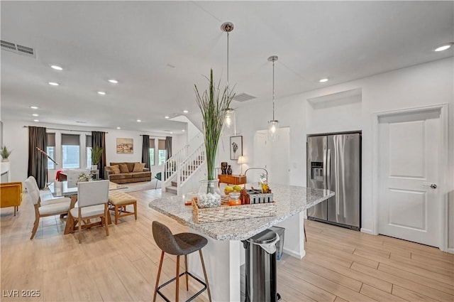 7756 Seville Estates Ct, Las Vegas, NV 89113 - kitchen featuring stainless steel fridge, light wood finished floors, light stone countertops, recessed lighting, and decorative light fixtures
