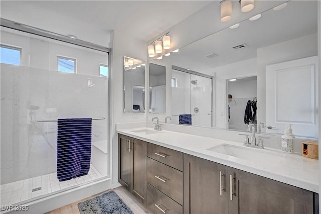 7756 Seville Estates Ct, Las Vegas, NV 89113 - full bathroom featuring a stall shower, double vanity, a spacious closet, and wood finished floors