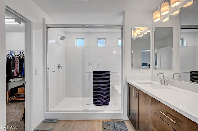 7756 Seville Estates Ct, Las Vegas, NV 89113 - bathroom featuring a shower stall, vanity, a walk in closet, and wood finished floors