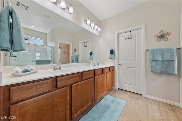 5375 E Ln Campana Dr, Pahrump, NV 89061 - bathroom featuring double vanity, a stall shower, and wood finished floors