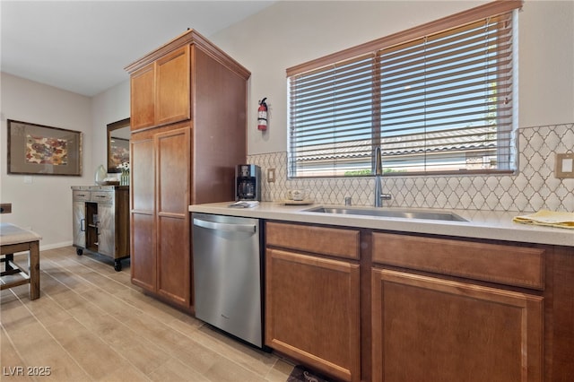 5375 E Ln Campana Dr, Pahrump, NV 89061 - kitchen with stainless steel dishwasher, tasteful backsplash, light countertops, brown cabinetry, and light wood-style floors