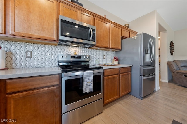 5375 E Ln Campana Dr, Pahrump, NV 89061 - kitchen featuring appliances with stainless steel finishes, light countertops, brown cabinetry, and light wood-style flooring
