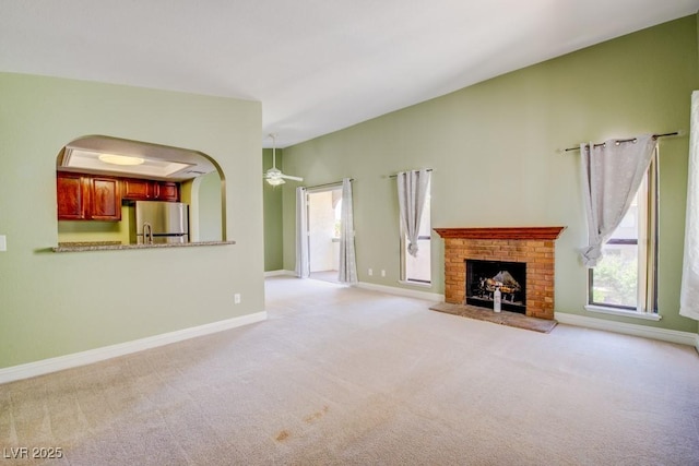 2212 Sunfish Dr Unit C, Henderson, NV 89014 - unfurnished living room featuring light colored carpet, a brick fireplace, and baseboards