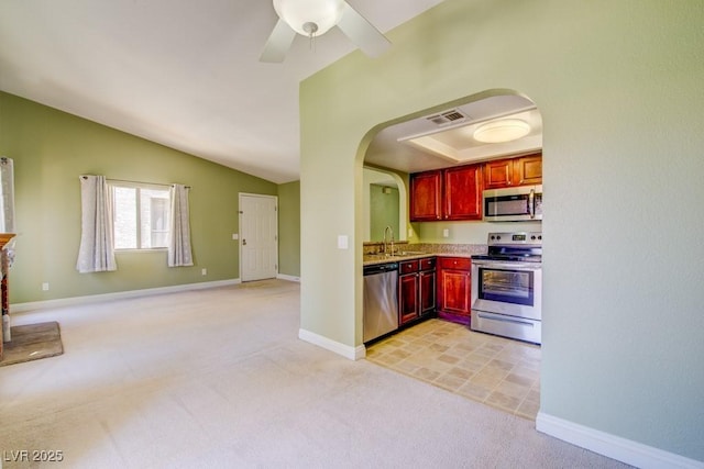 2212 Sunfish Dr Unit C, Henderson, NV 89014 - kitchen with appliances with stainless steel finishes, reddish brown cabinets, arched walkways, a sink, and light colored carpet