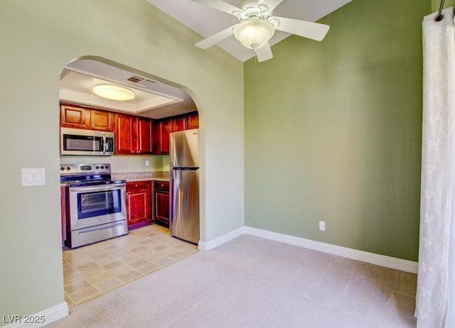 2212 Sunfish Dr Unit C, Henderson, NV 89014 - kitchen with appliances with stainless steel finishes, arched walkways, reddish brown cabinets, and light carpet