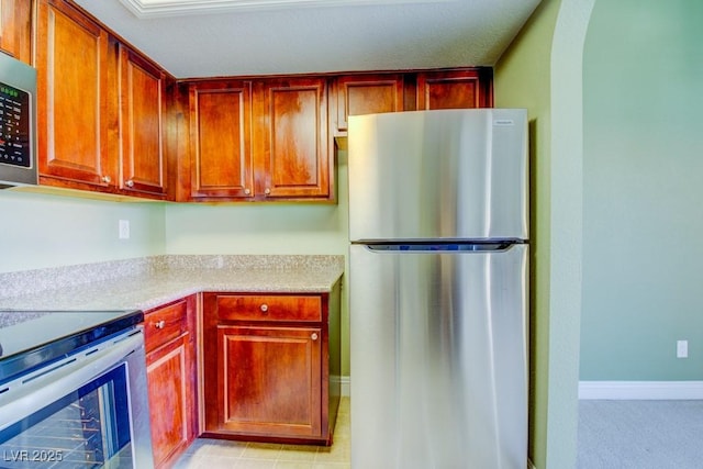 2212 Sunfish Dr Unit C, Henderson, NV 89014 - kitchen with appliances with stainless steel finishes, light countertops, arched walkways, and baseboards