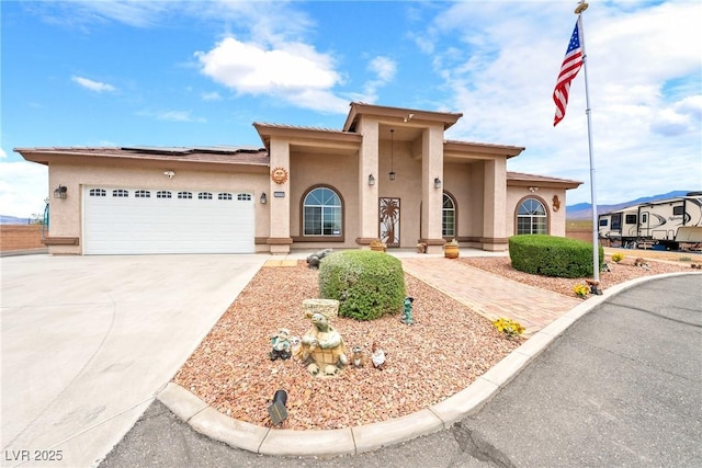 2020 S Omaha Ave, Pahrump, NV 89048 - mediterranean / spanish-style house featuring stucco siding, solar panels, driveway, and an attached garage