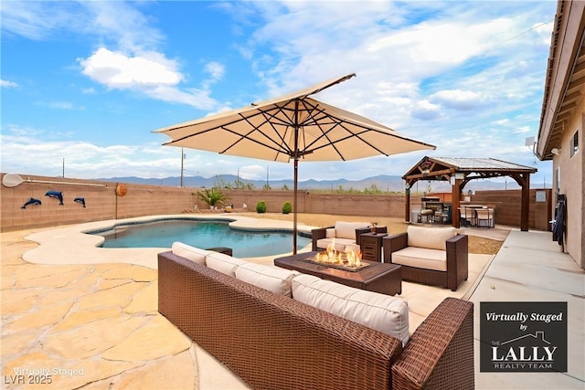 2020 S Omaha Ave, Pahrump, NV 89048 - view of swimming pool featuring an outdoor living space with a fire pit, a gazebo, a mountain view, a patio area, and a fenced backyard