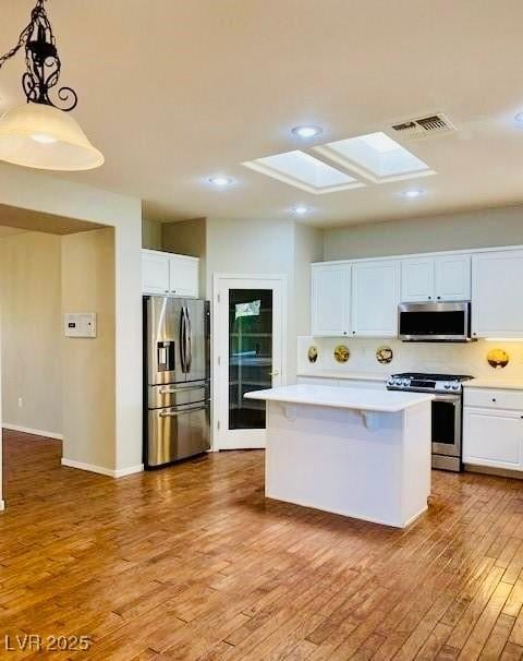 1941 Williamsport St, Henderson, NV 89052 - kitchen featuring stainless steel appliances, a skylight, light countertops, white cabinetry, and light wood-style floors