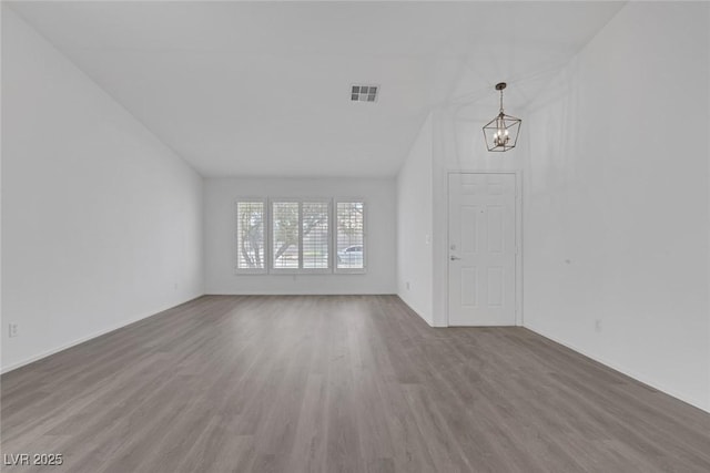 5808 Spinnaker Reach Ave, Las Vegas, NV 89130 - unfurnished living room with a chandelier, wood finished floors, baseboards, and vaulted ceiling