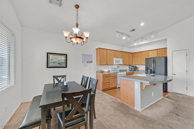 9105 White Eyes Ave, Las Vegas, NV 89143 - kitchen featuring white appliances, a chandelier, light colored carpet, an island with sink, and light countertops