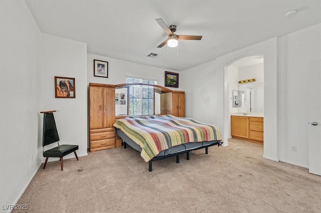 9105 White Eyes Ave, Las Vegas, NV 89143 - bedroom featuring light colored carpet, arched walkways, a ceiling fan, and ensuite bath