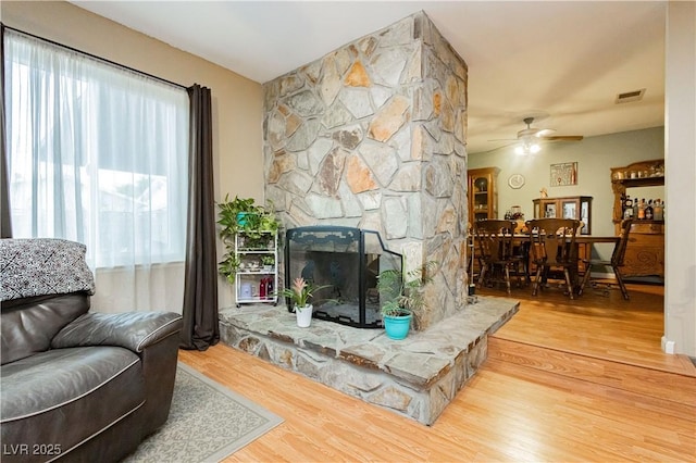 7701 Pheasant Ln, Las Vegas, NV 89145 - living area with wood finished floors, a ceiling fan, and a fireplace