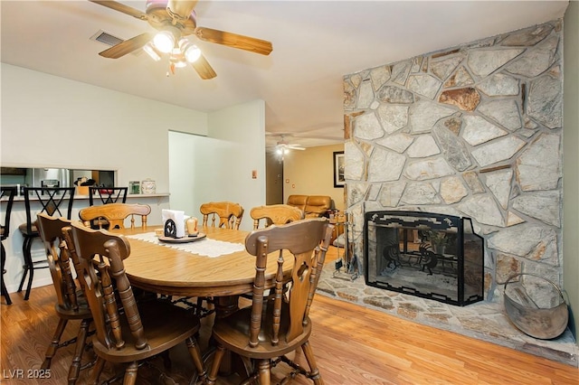 7701 Pheasant Ln, Las Vegas, NV 89145 - dining area with ceiling fan, wood finished floors, and a stone fireplace