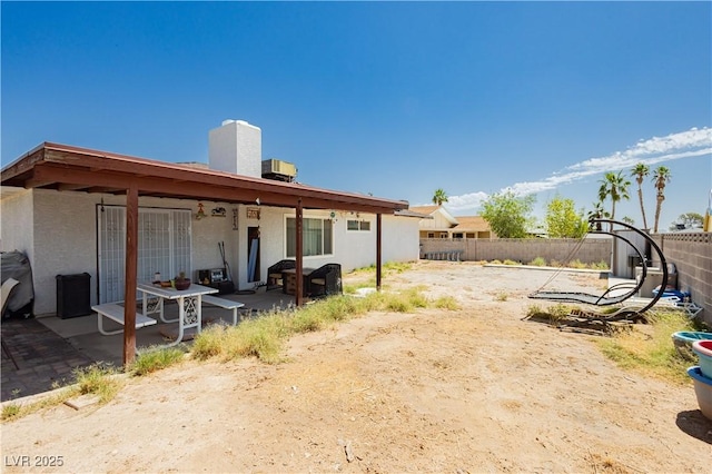 7701 Pheasant Ln, Las Vegas, NV 89145 - back of property featuring a patio, a fenced backyard, stucco siding, and a chimney