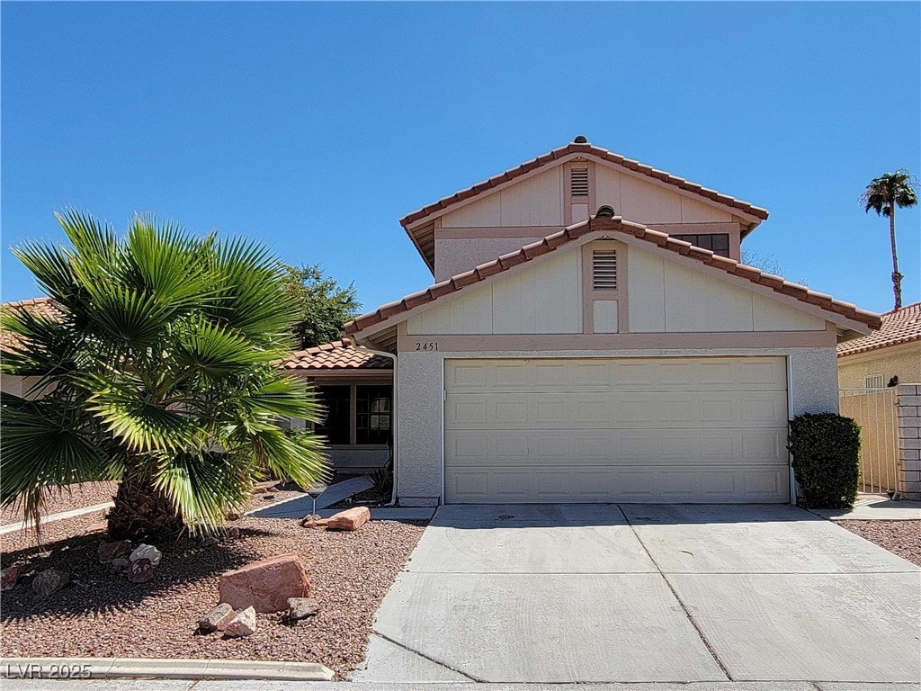2451 Muirfield Ave, Henderson, NV 89074 - mediterranean / spanish house featuring a tile roof, concrete driveway, and a garage