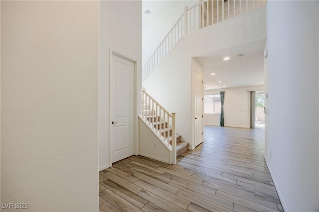 6403 Ava Ridge Ave, Las Vegas, NV 89141 - hallway with wood finished floors, stairs, baseboards, a towering ceiling, and recessed lighting