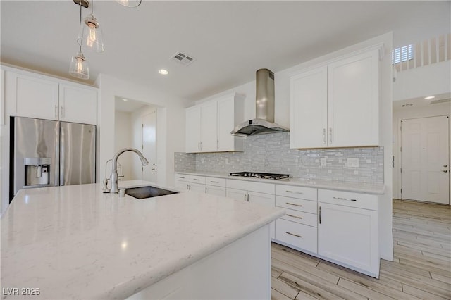 6403 Ava Ridge Ave, Las Vegas, NV 89141 - kitchen featuring wall chimney exhaust hood, stainless steel fridge with ice dispenser, a sink, light stone countertops, and white cabinets