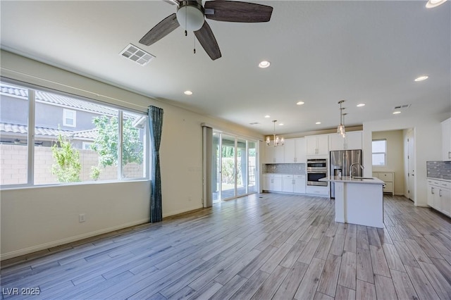6403 Ava Ridge Ave, Las Vegas, NV 89141 - kitchen with stainless steel appliances, a chandelier, plenty of natural light, a sink, and recessed lighting