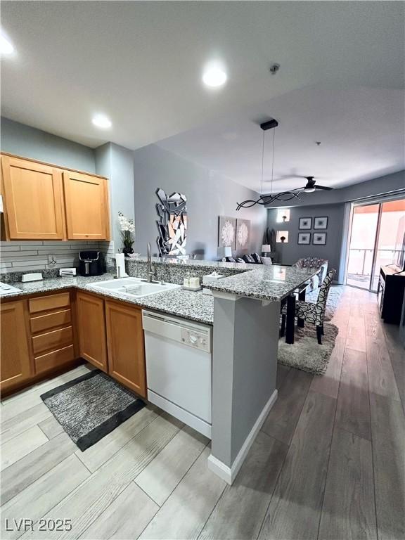 23 E Agate Ave Unit 301, Las Vegas, NV 89123 - kitchen with white dishwasher, a sink, a peninsula, a ceiling fan, and open floor plan
