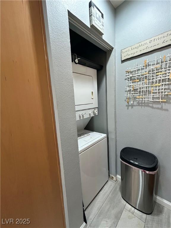 23 E Agate Ave Unit 301, Las Vegas, NV 89123 - laundry room featuring estacked washer and dryer, baseboards, and light wood finished floors