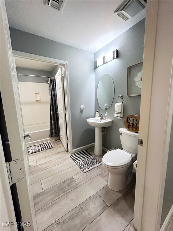23 E Agate Ave Unit 301, Las Vegas, NV 89123 - full bathroom featuring toilet, wood tiled floors, and shower / tub combo