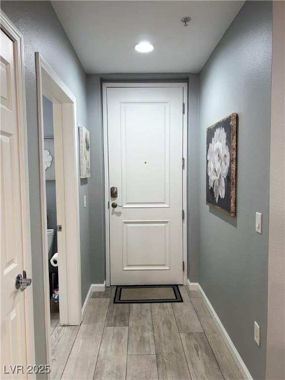 23 E Agate Ave Unit 301, Las Vegas, NV 89123 - doorway to outside featuring light wood-style floors and baseboards