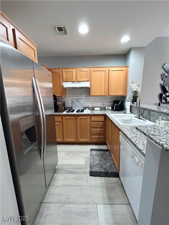 23 E Agate Ave Unit 301, Las Vegas, NV 89123 - kitchen featuring white appliances, a sink, under cabinet range hood, light stone countertops, and tasteful backsplash