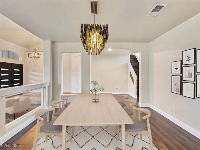 6639 Tranquil Seas Ct, Las Vegas, NV 89139 - dining space featuring a chandelier, wood finished floors, baseboards, stairs, and arched walkways