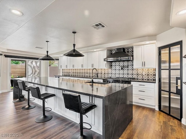 6639 Tranquil Seas Ct, Las Vegas, NV 89139 - kitchen with wall chimney exhaust hood, a sink, dark wood-style flooring, decorative backsplash, and recessed lighting