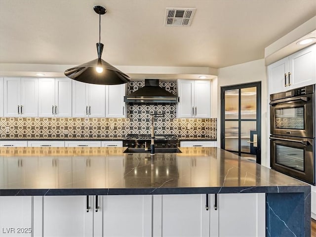 6639 Tranquil Seas Ct, Las Vegas, NV 89139 - kitchen featuring premium range hood, double oven, dark countertops, decorative backsplash, and white cabinets