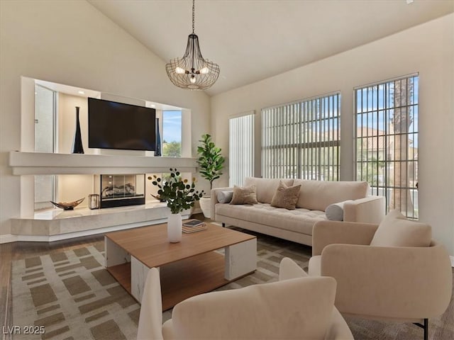 6639 Tranquil Seas Ct, Las Vegas, NV 89139 - living area with high vaulted ceiling, a chandelier, wood finished floors, a tile fireplace, and baseboards